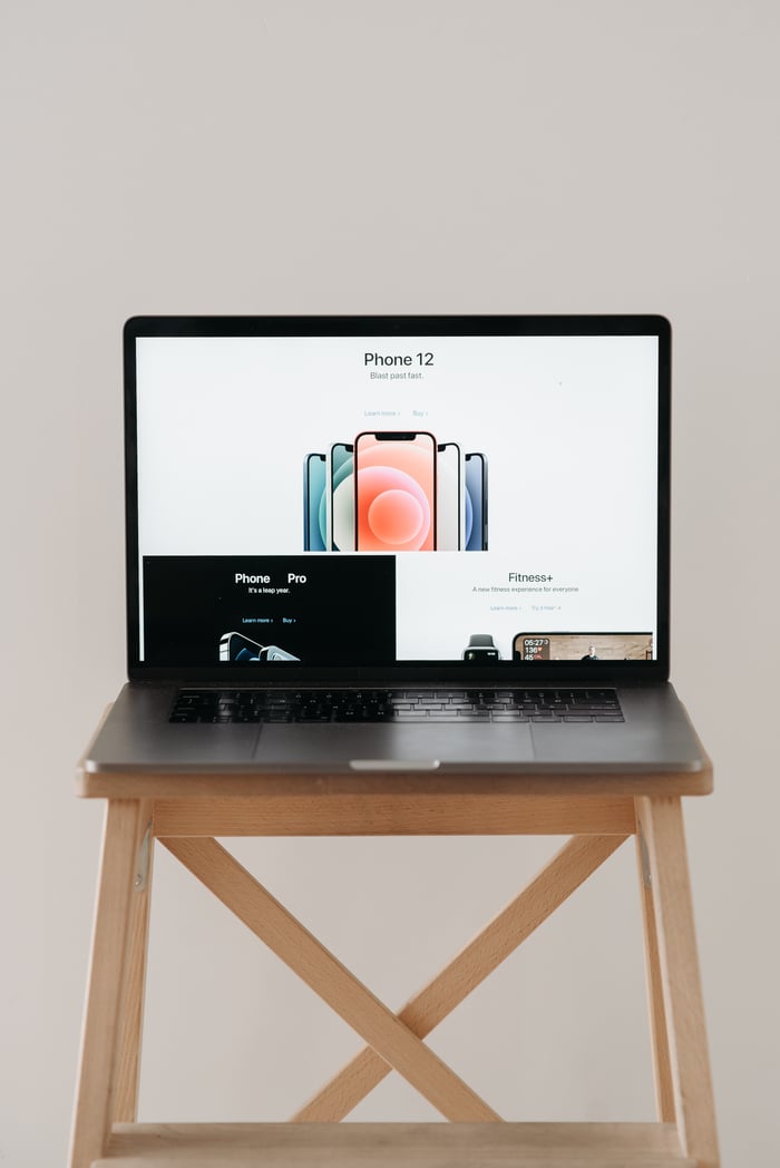 The Art of Drawing Readers In: Your attractive post title goes here A sleek laptop on a wooden table showing a smartphone advertisement, perfect for tech and gadget content.