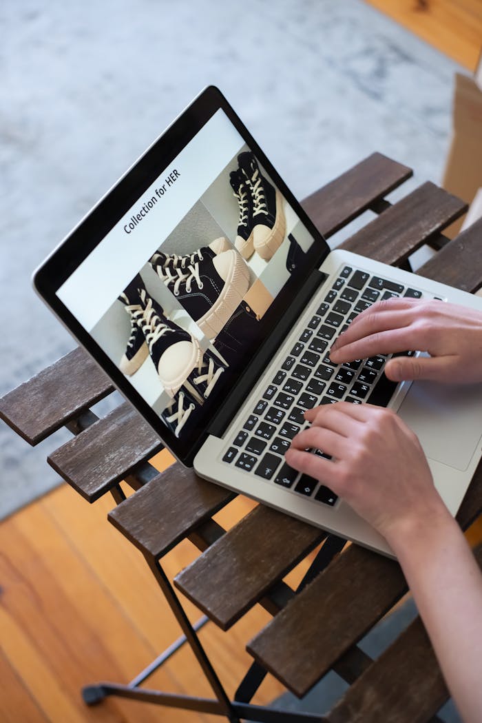 Mastering the First Impression: Your intriguing post title goes here Hands browsing sneakers on laptop, showcasing online store shopping experience.